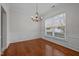 Elegant dining room with hardwood floors, wainscoting, chandelier, and a view to the outside through large window at 11425 Shadow Elms Ln, Raleigh, NC 27614