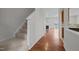 Hallway with wooden floors and staircase leading to the carpeted upstairs, kitchen view to right at 11425 Shadow Elms Ln, Raleigh, NC 27614