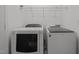 A tidy laundry room with a white washer and dryer set provides functionality and convenience for homeowners at 11425 Shadow Elms Ln, Raleigh, NC 27614