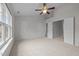 Spacious main bedroom with neutral carpeting, ceiling fan, and ensuite bathroom entryways for comfortable living at 11425 Shadow Elms Ln, Raleigh, NC 27614