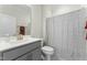 Clean bathroom featuring a single vanity with modern fixtures and a toilet in front of a shower with a gray curtain at 1255 White Flint Cir, Durham, NC 27703