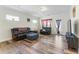 Comfortable living room with a dark brown leather sofa, laminate floors, and a view to the porch at 1255 White Flint Cir, Durham, NC 27703