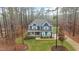 Aerial view of a blue two-story home with a covered front porch surrounded by trees at 130 Willow Bend Dr, Youngsville, NC 27596