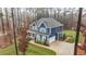 Aerial view of a blue two-story home with a manicured lawn and mature trees at 130 Willow Bend Dr, Youngsville, NC 27596