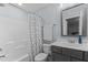 Well-lit bathroom featuring a shower with patterned curtain and sleek vanity with modern fixtures at 130 Willow Bend Dr, Youngsville, NC 27596