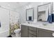Bathroom with double vanity, shower-tub, white floral shower curtain, and matching mirrors at 130 Willow Bend Dr, Youngsville, NC 27596