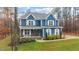 Charming two-story home with a blue exterior, covered front porch, and landscaped yard at 130 Willow Bend Dr, Youngsville, NC 27596