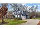 Blue home with white trim, a two-car garage, well manicured lawn and mature landscaping at 130 Willow Bend Dr, Youngsville, NC 27596