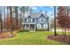 Charming two-story blue home with a well-manicured front yard surrounded by mature trees at 130 Willow Bend Dr, Youngsville, NC 27596