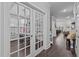 Hallway with french doors leading to the office and open views to dining and living spaces at 130 Willow Bend Dr, Youngsville, NC 27596