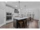 Open kitchen with an island featuring a white countertop, dark cabinets, and modern pendant lighting at 130 Willow Bend Dr, Youngsville, NC 27596