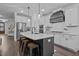Kitchen featuring white cabinetry, stainless steel appliances, a central island with bar stools, and modern lighting at 130 Willow Bend Dr, Youngsville, NC 27596