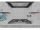 Close-up shot of kitchen cooktop, tile backsplash, and modern vent hood at 130 Willow Bend Dr, Youngsville, NC 27596