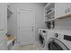 Well-organized laundry room with shelving and modern washer and dryer at 130 Willow Bend Dr, Youngsville, NC 27596