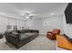 Spacious living room with large sofa, a ceiling fan, and natural light from multiple windows at 130 Willow Bend Dr, Youngsville, NC 27596