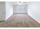 Bedroom featuring neutral carpeting, ceiling fan, a large window and a door leading to a closet at 1628 Beacon Village Dr, Raleigh, NC 27604