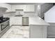 Bright kitchen with stainless steel appliances, white cabinets, and tile flooring at 1628 Beacon Village Dr, Raleigh, NC 27604