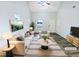 Bright, staged living room with modern furnishings, hardwood floor, and a vaulted ceiling at 1628 Beacon Village Dr, Raleigh, NC 27604