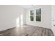 Bright bedroom with gray hardwood floors and a double window letting in plenty of natural light at 1915 Lambert Rd, Graham, NC 27253