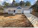 Aerial view of a single-story home with a covered porch, attached garage, and long driveway at 1915 Lambert Rd, Graham, NC 27253
