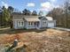Exterior view of a charming single-story home with blue siding, a covered porch, and a driveway at 1915 Lambert Rd, Graham, NC 27253