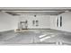 Spacious garage featuring concrete flooring, large windows, and a water heater with stairs to the attic at 1915 Lambert Rd, Graham, NC 27253