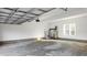 Bright garage with a concrete floor, water heater, stairs, and large windows for natural light at 1915 Lambert Rd, Graham, NC 27253