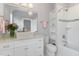 Bright bathroom with a granite countertop vanity, stylish mirror, tiled shower/bath, and open shelving at 2005 Bernard St, Raleigh, NC 27608