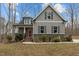 Charming two-story home with gray siding, stone accents, and a welcoming red front door at 2482 Golden Forest Dr, Franklinton, NC 27525