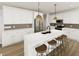 Bright, open kitchen featuring white cabinets, stainless steel appliances, and a large island at 249 Beacon Dr, Pittsboro, NC 27312