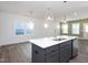 Bright kitchen with a gray island, white cabinets, stainless steel appliances, and open floorplan at 257 Beacon Dr, Pittsboro, NC 27312