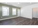 Comfortable living room with wood floors, neutral paint, two windows, and an entry to the backyard at 257 Beacon Dr, Pittsboro, NC 27312