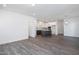 Open-concept living room showcasing gray hardwood floors and a seamless transition into the modern kitchen at 257 Beacon Dr, Pittsboro, NC 27312
