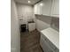Practical laundry area features white cabinetry, utility sink, and modern fixtures at 306 Brier Summit Pl, Durham, NC 27703