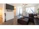 Open living room featuring a sectional sofa, TV, and staircase, with a window seat providing additional comfort at 306 Brier Summit Pl, Durham, NC 27703