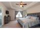 Spacious main bedroom features a ceiling fan, tray ceiling, ensuite bathroom, and large window at 306 Brier Summit Pl, Durham, NC 27703