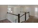 Upstairs hallway featuring wood railing and neutral carpet at 326 Umstead St, Sanford, NC 27330