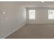 A neutral room features smooth walls, base trim, and two windows at 326 Umstead St, Sanford, NC 27330