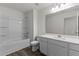 Clean bathroom with a shower-tub combo, white cabinets, and a large mirror at 40 Rolling Banks Dr, Louisburg, NC 27549