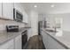 Modern kitchen features gray cabinets, stainless steel appliances, and granite countertops at 40 Rolling Banks Dr, Louisburg, NC 27549