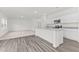 Bright, open-concept living area features modern wood-look flooring, a kitchen island and neutral paint at 40 Rolling Banks Dr, Louisburg, NC 27549
