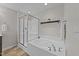 Bright bathroom showcasing a soaking tub with a showerhead, white tile surround, and neutral paint at 532 Smithridge Way, Fuquay Varina, NC 27526