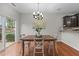 Cozy dining area with hardwood floors, modern chandelier, and a sliding glass door to the backyard at 532 Smithridge Way, Fuquay Varina, NC 27526