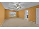 Bright main bedroom featuring a ceiling fan, neutral carpet, and a view to the backyard at 532 Smithridge Way, Fuquay Varina, NC 27526