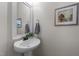 Stylish powder room with a pedestal sink, decorative mirror, and fresh paint at 532 Smithridge Way, Fuquay Varina, NC 27526