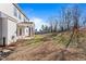 Large backyard with trees beyond the lawn, fence, and a covered patio at 594 Executive Dr, Lillington, NC 27546