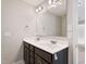 Bathroom with double sink vanity, dark cabinets, and a large mirror with decorative lighting at 594 Executive Dr, Lillington, NC 27546