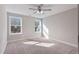 Sun-filled bedroom with carpet flooring, a ceiling fan and two bright windows at 594 Executive Dr, Lillington, NC 27546