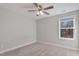 Bright bedroom boasts carpet flooring, ceiling fan, window overlooking backyard at 594 Executive Dr, Lillington, NC 27546