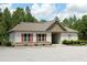 Charming clubhouse featuring red-shuttered windows, stone accents, and ample parking at 594 Executive Dr, Lillington, NC 27546